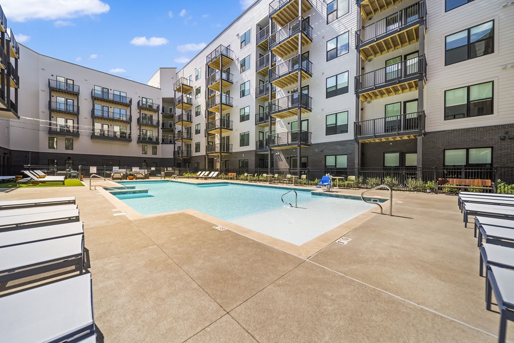 A swimming pool in a courtyard surrounded by apartment buildings.