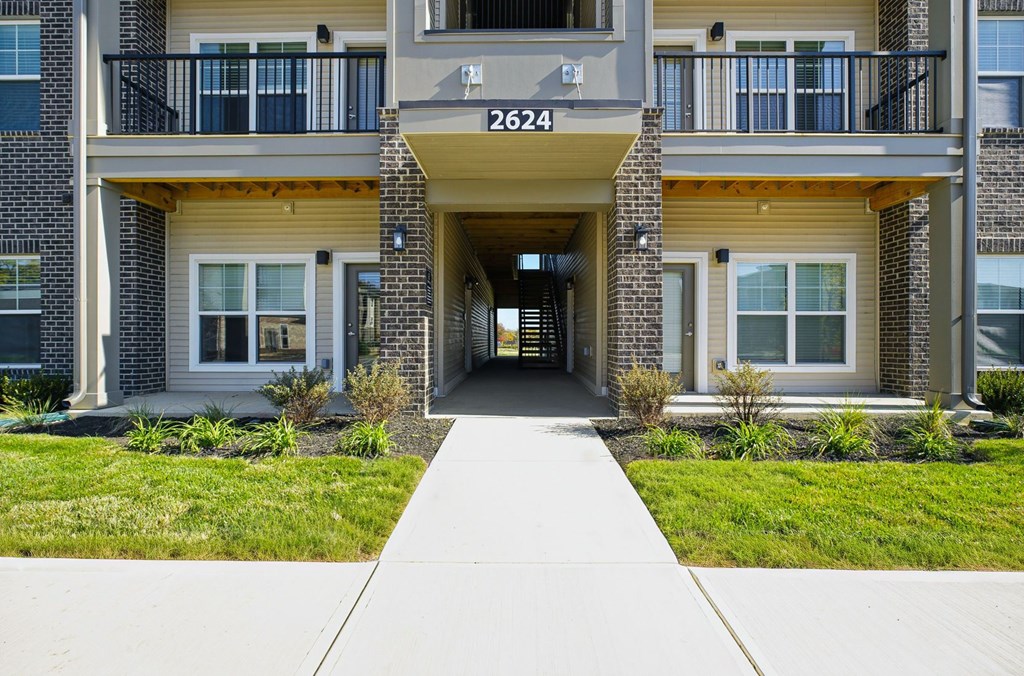 The image shows the front of apartment building number 2624 with a walkway leading to the entrance.