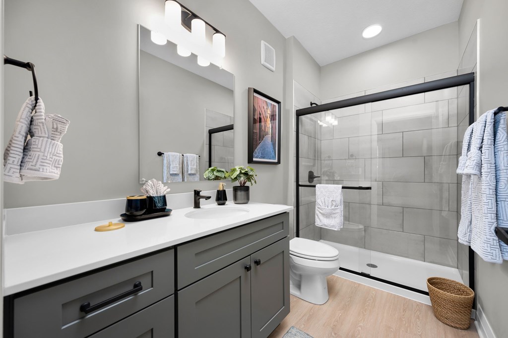 A bathroom with a white countertop and a white toilet.