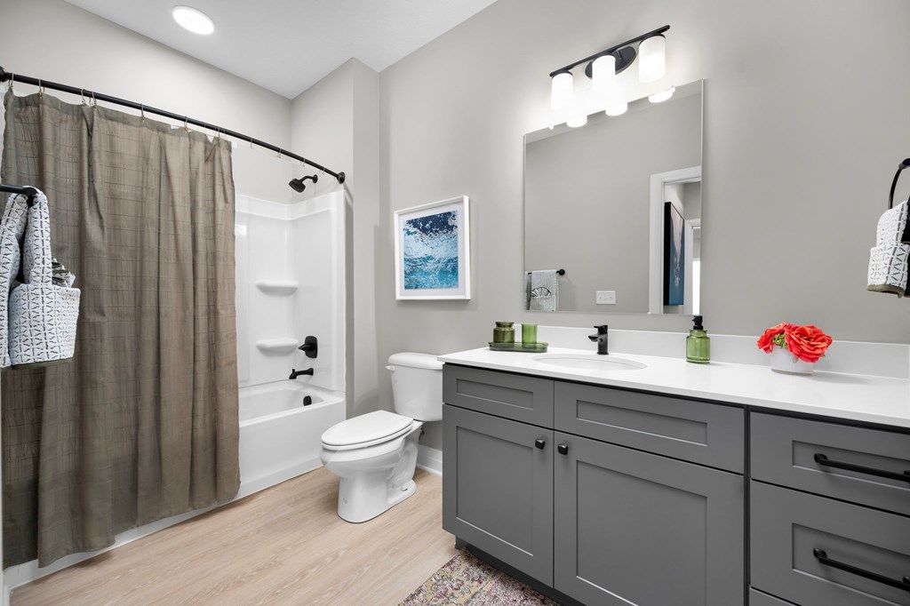 A bathroom with a toilet, sink, and shower.