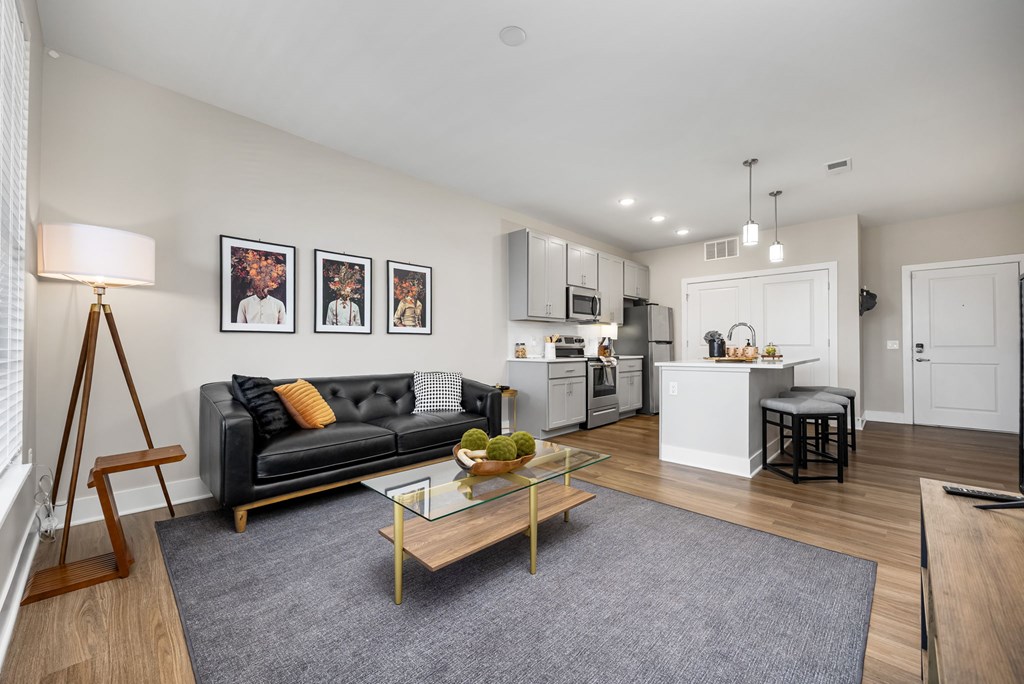 A modern living room with a black couch and a coffee table.