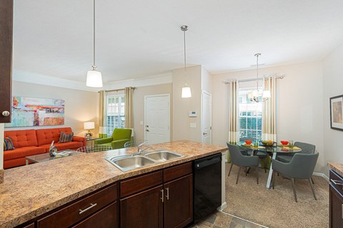 an open kitchen and living room with a dining room table and chairs