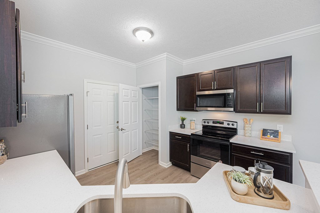 a kitchen with black appliances and brown cabinets