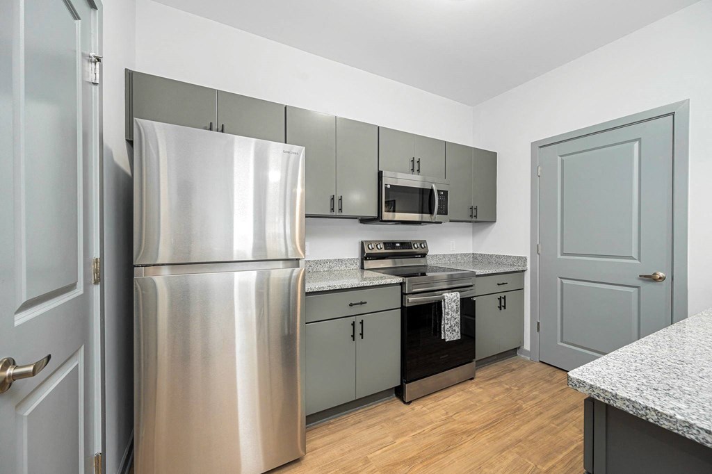 a kitchen with stainless steel appliances and gray cabinets