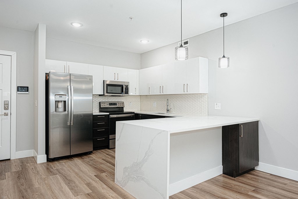 a kitchen with white cabinets and a stainless steel refrigerator