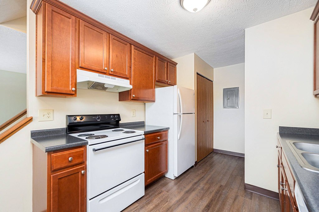 a kitchen with white appliances and wooden cabinets