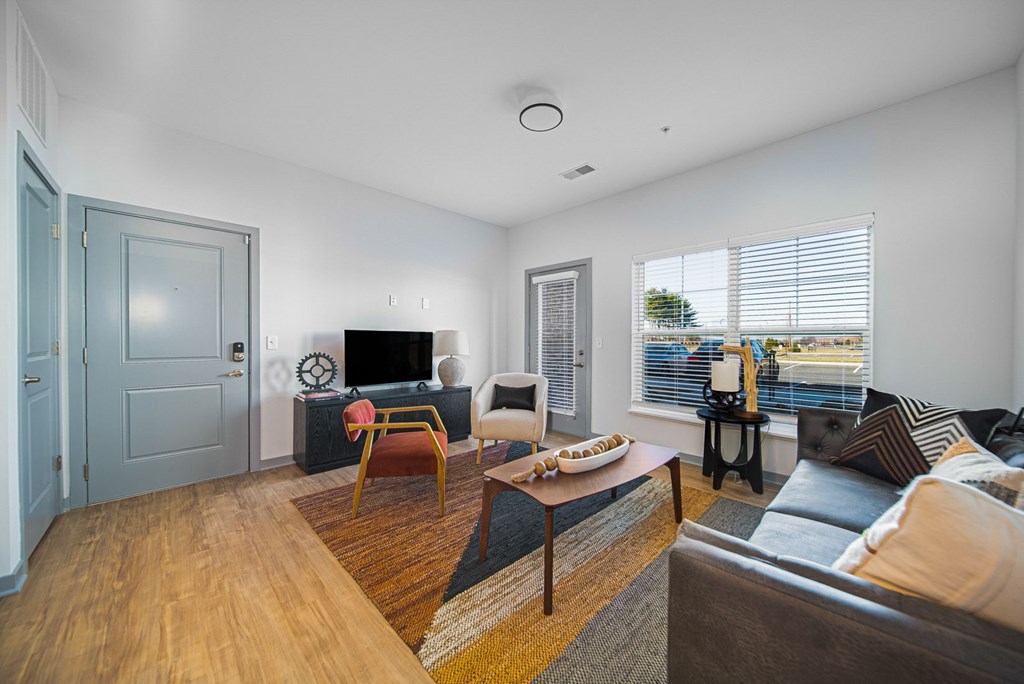 A living room with a grey door and a brown sofa.