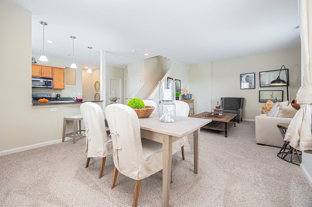 A dining room with a table and chairs.