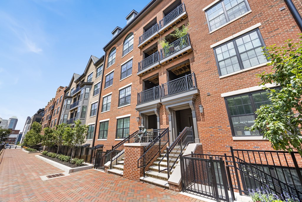 A red brick building with a black metal railing.