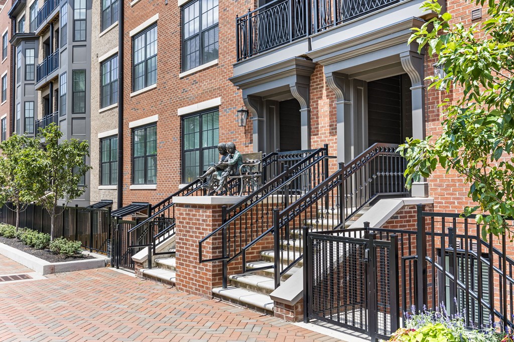 A red brick building with a black railing and steps.