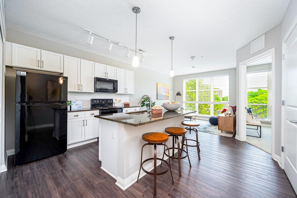 a kitchen with a large island with three stools