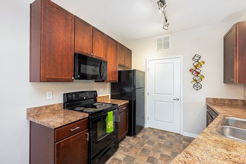 a kitchen with black appliances and granite counter tops