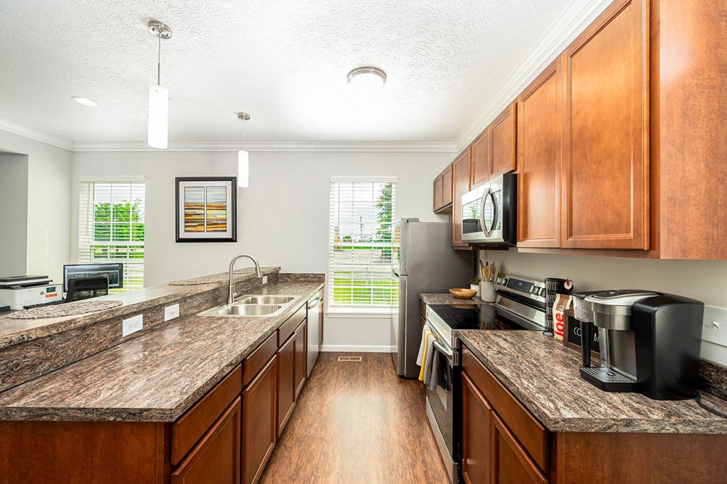 a kitchen with wooden cabinets and granite counter tops