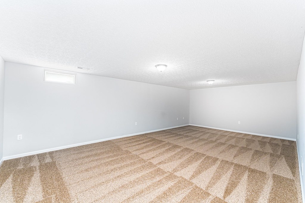 A room with a carpeted floor and white walls.