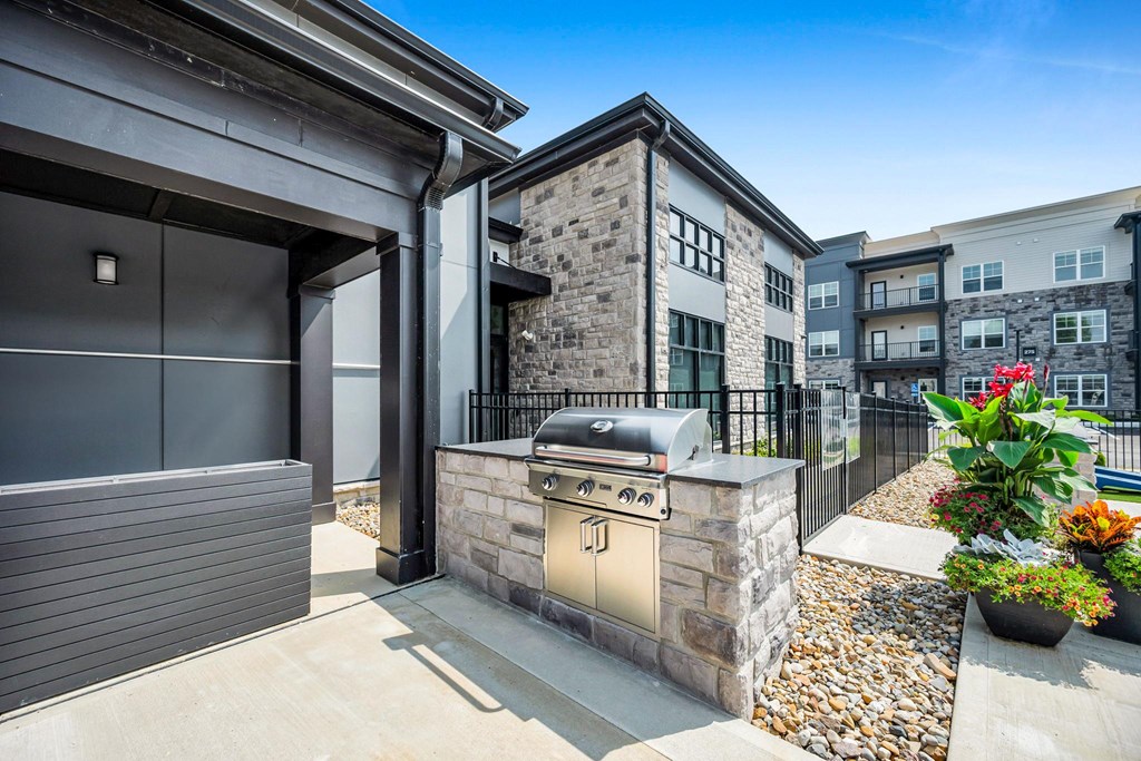 A modern house with a stone facade and a black gate.