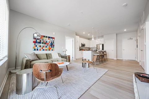 A modern living room with a grey sofa and a wooden chair.