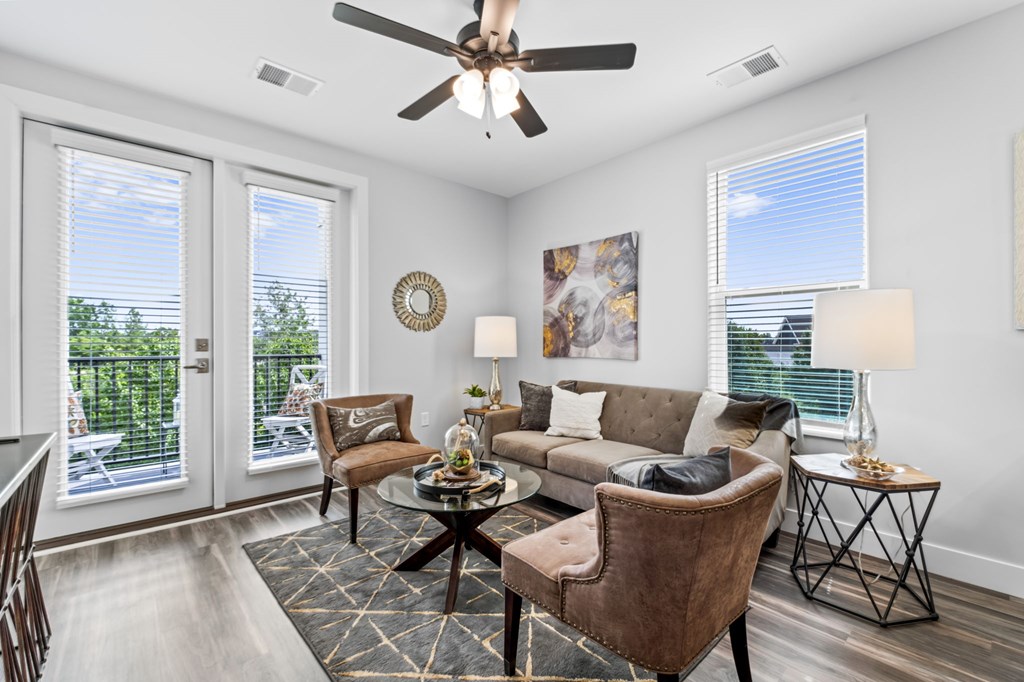 A living room with a brown chair and a brown couch.