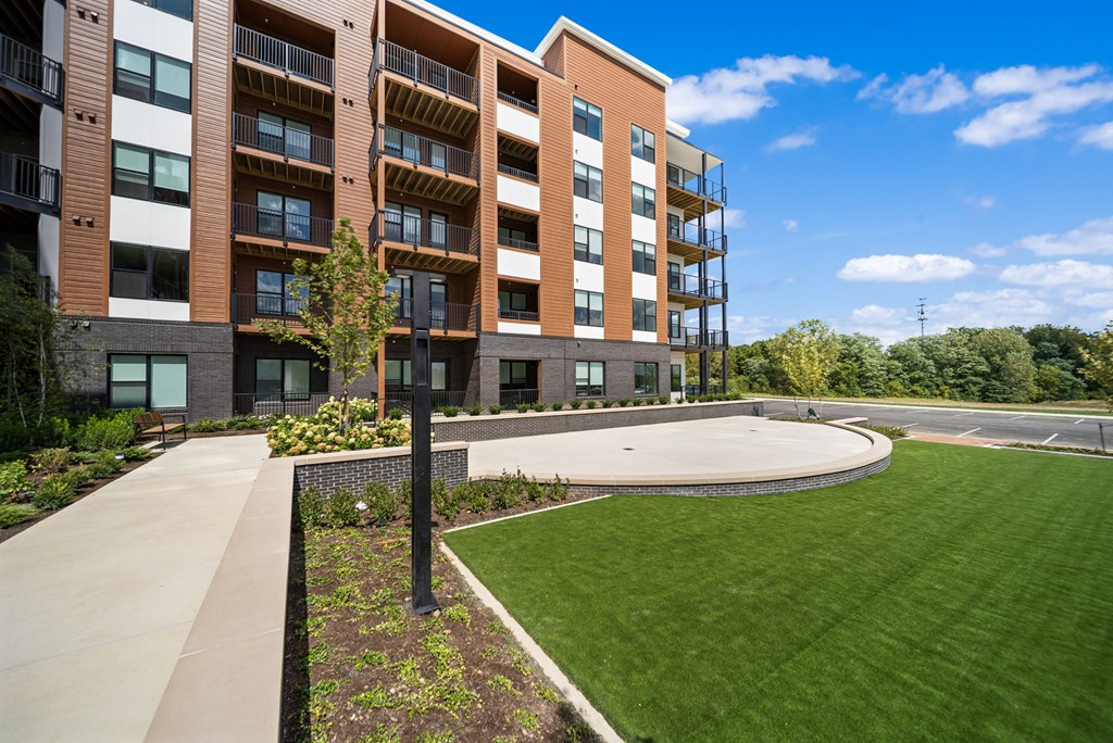 A modern apartment building with a well-maintained lawn in front.
