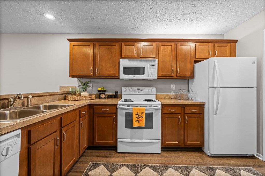 A kitchen with wooden cabinets and a white refrigerator.