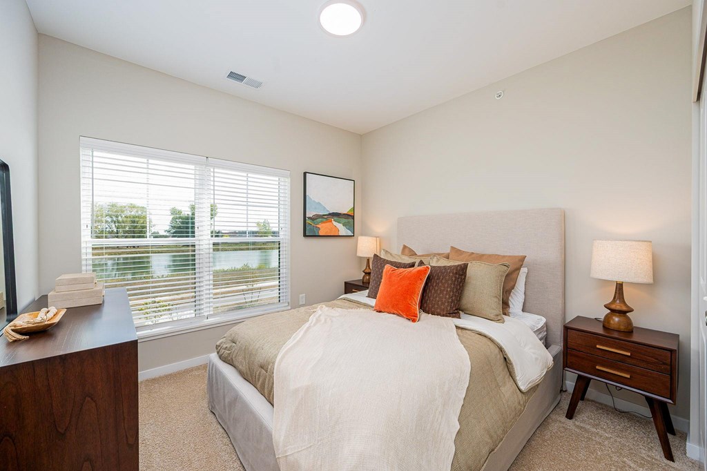 A bedroom with a large bed and a painting on the wall.