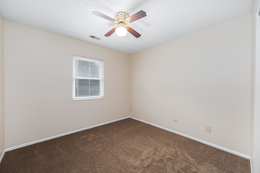 a bedroom with carpet and a ceiling fan
