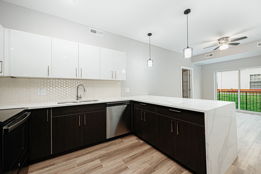 a large kitchen with white counter tops and black cabinets