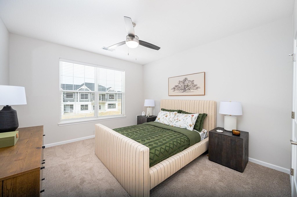 A bedroom with a large bed and a ceiling fan.