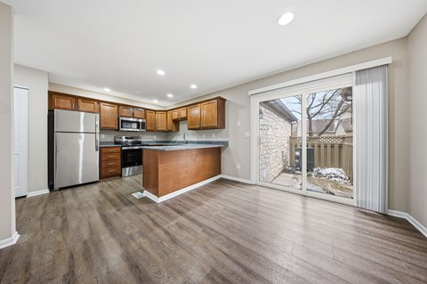 A kitchen with wooden cabinets and a refrigerator.