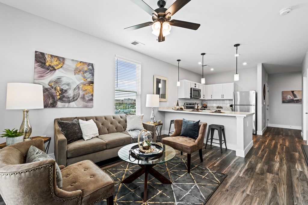 A modern living room with a grey sofa, a coffee table, and a ceiling fan.