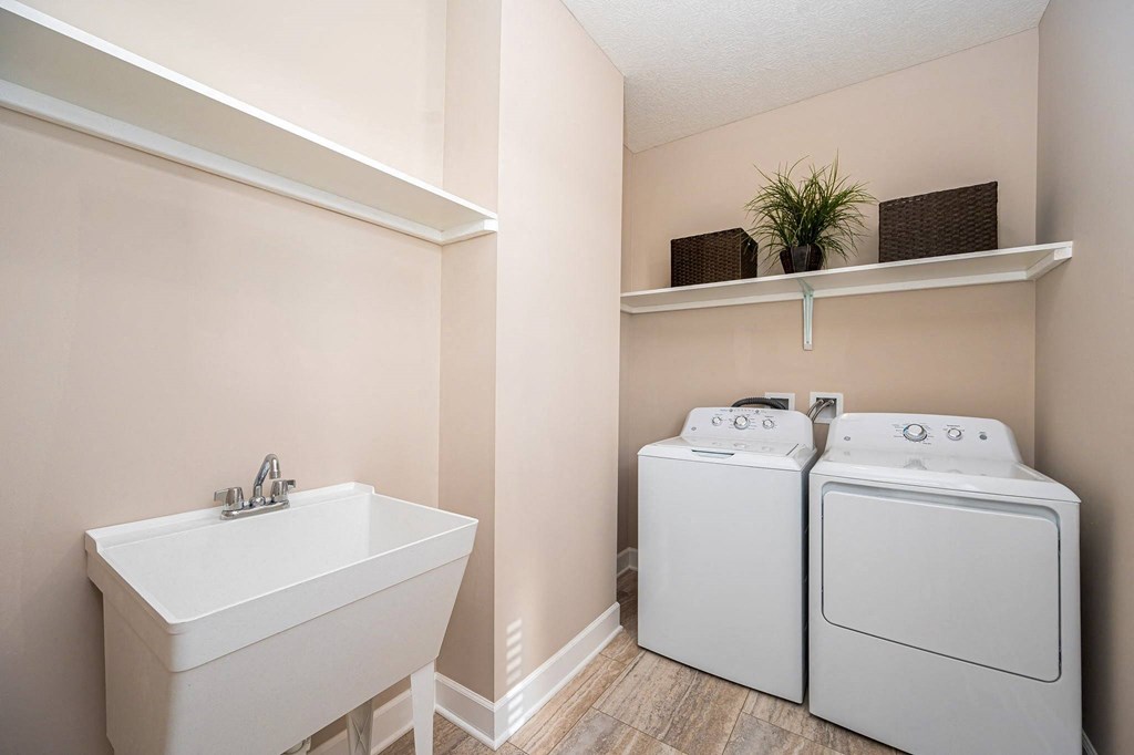 a laundry room with a sink and a washer and dryer