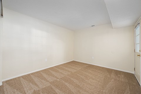 an empty room with carpet and a door