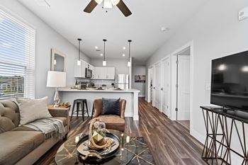 A modern living room with a brown sofa and a wooden floor.