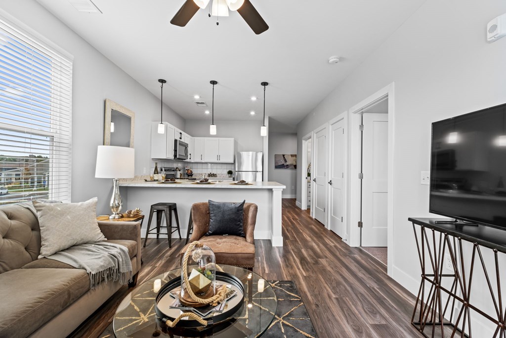 A modern living room with a brown sofa and a wooden floor.
