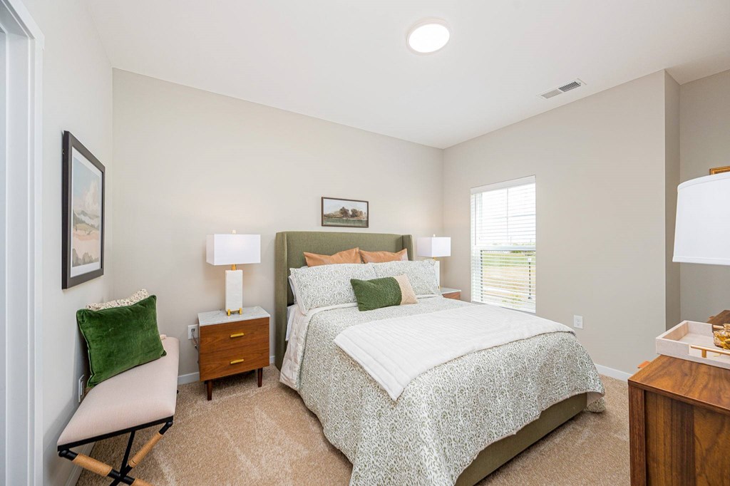 A bedroom with a large bed and a chair.