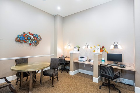 a conference room with a round table and a desk with a computer
