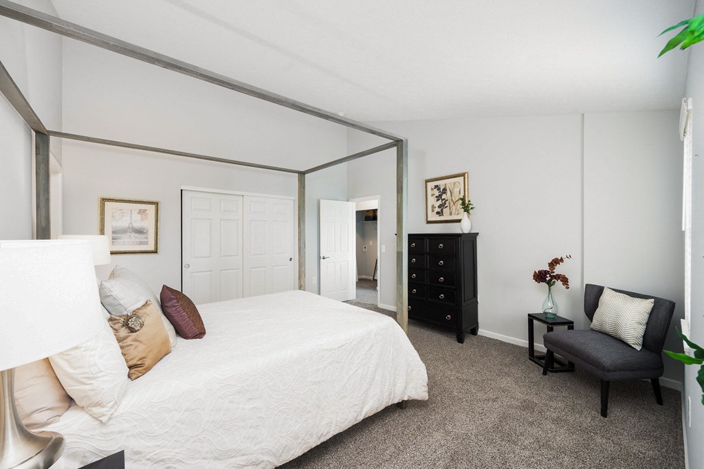 a bedroom with a large bed and a large mirror