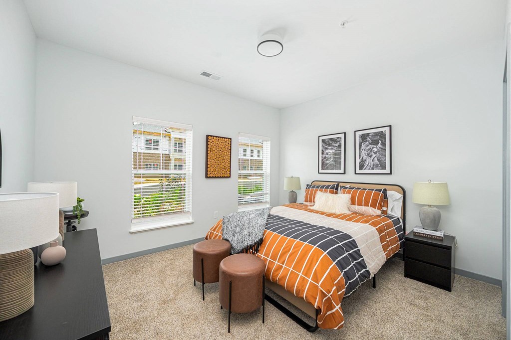 a bedroom with a bed and two windows