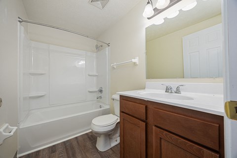 A white toilet sits next to a white sink in a bathroom.