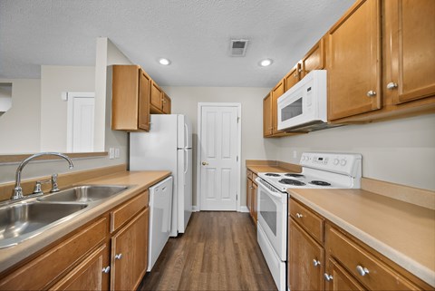 A kitchen with wooden cabinets and white appliances.
