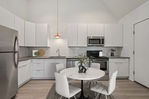 A modern kitchen with a white table and chairs.