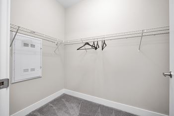 A white closet with a metal rack and a white door.