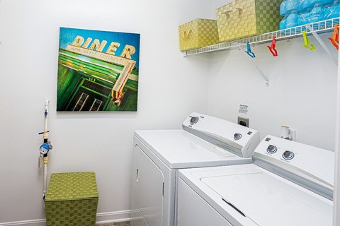 a laundry room with two washing machines and a painting on the wall