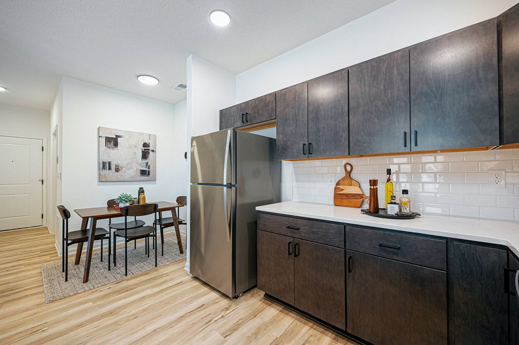 a kitchen with wooden cabinets and a stainless steel refrigerator