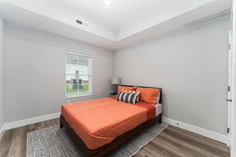 A bedroom with a bed and a window.