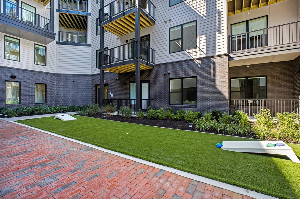 A modern apartment complex with a red brick walkway.