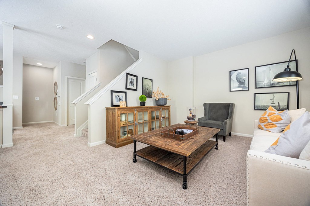 A living room with a couch, coffee table, and pictures on the wall.
