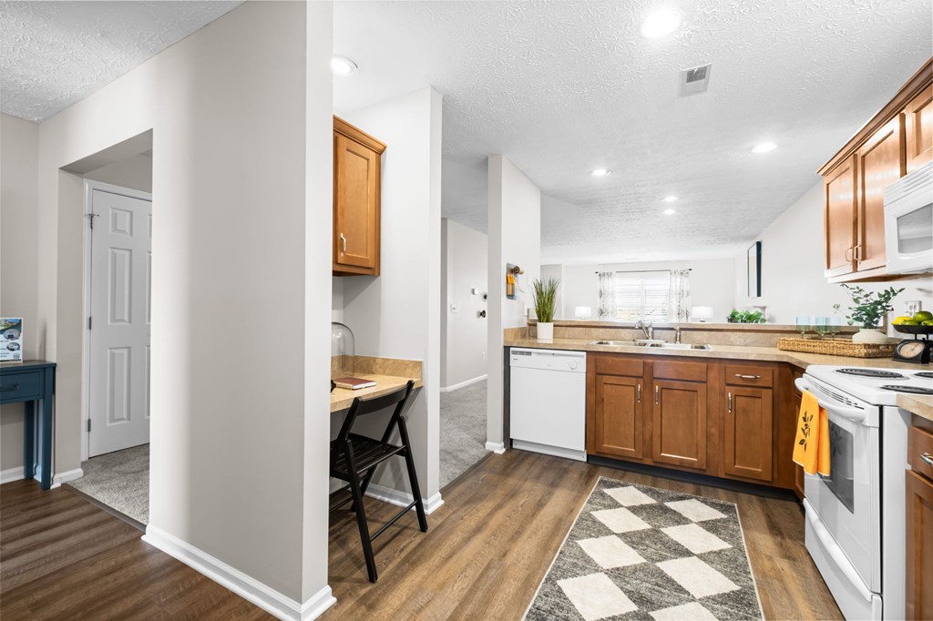 A kitchen with white appliances and wooden cabinets.