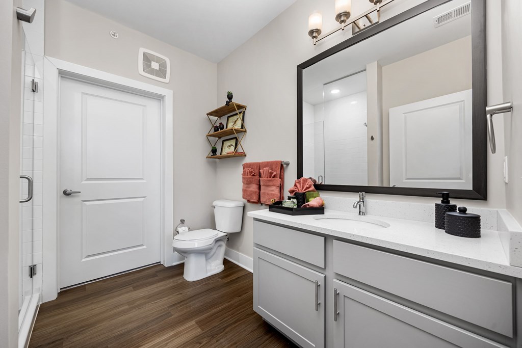 A white bathroom with a toilet, sink, and mirror.