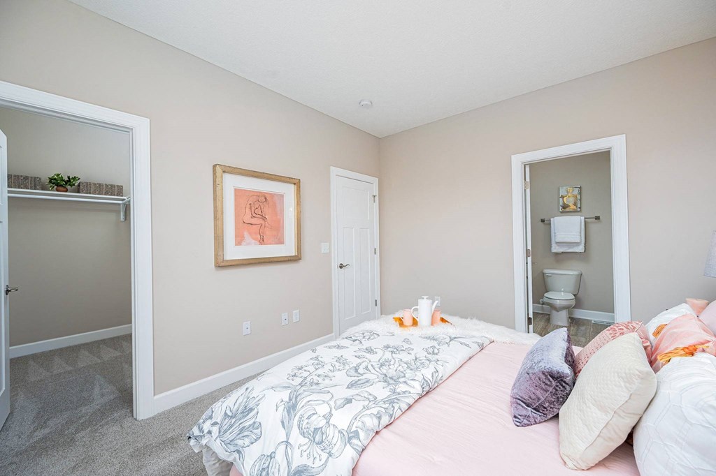 a bedroom with a bed and a door to a bathroom