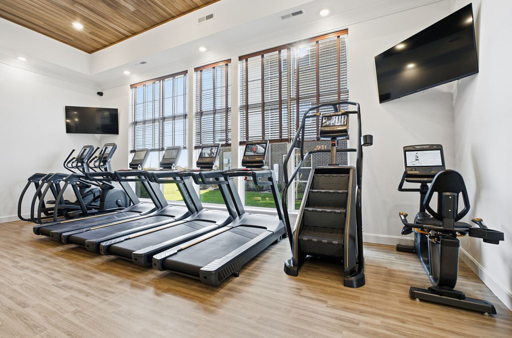 A gym with treadmills, elliptical machines, and a stair climber.